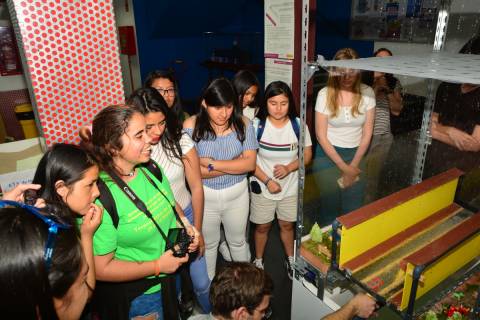 Estudiantes comprobando la capacidad de la maqueta de una red de drenaje para canalizar agua de lluvia.