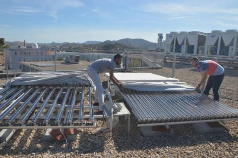 Dos jóvenes investigadores de la UPCT descubriendo un colector de energía solar.