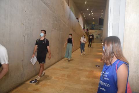 Una alumna de la UPCT voluntaria observa la entrada en fila de estudiantes en la EBAU de julio.