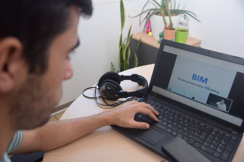 Un joven observando una conferencia sobre metodología BIM grabada en la UPCT.