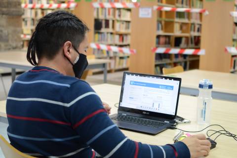 Un alumno en la sala de lectura del CRAI Biblioteca del Campus de la Muralla.