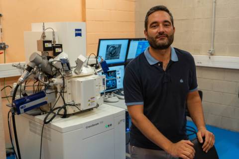 Javier Cerrillo  junto al microscopio electrónico de barrido con columna de doble haz con que cuenta la UPCT.