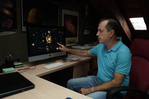 Anastasio Díaz, en su despacho de la UPCT, mostrando las cuatro imágenes de la galaxia que aparentan la forman de un anillo.