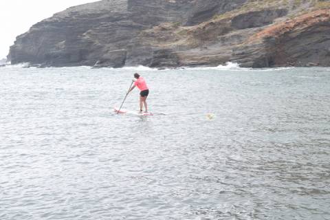 Amaia Gómez, con una tabla de paddle surf y el instrumento de recogida de muestras.