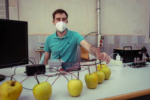 Francisco Martínez, voluntario de IEEE, pulsando una de las manzanas del teclado electrónico.