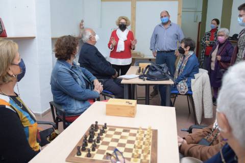 La concejal y el vicerrector saludando a los usuarios y al monitor del taller de ajedrez intergeneracional.