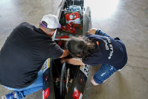 Dos integrantes del equipo realizando ajustes en el vehículo.