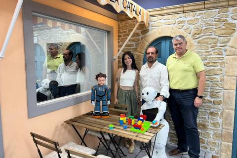 Gema Benedicto, José Manuel Ferrández y Eduardo Hurtado junto a los robots Milo y Pepper en el laboratorio que simula una cafetería.