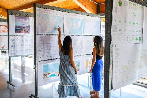 Dos alumnas observando los proyectos expuestos.