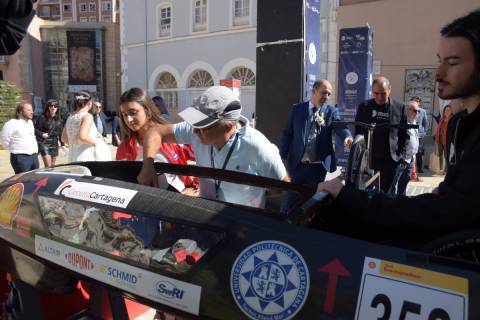 El exalumno Manuel Pérez, vestido de novio, conversa con José Luis Serrano, coordinador de Divulgación, junto al vehículo del UPCT Solar Team.