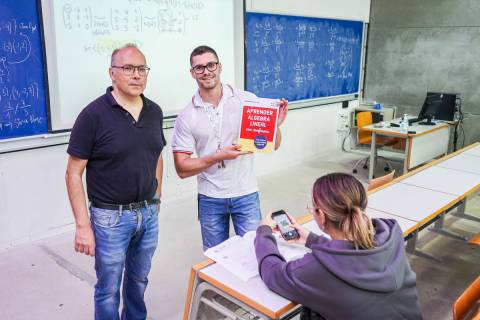 Juan Medina junto a dos estudiantes con su nuevo libro.