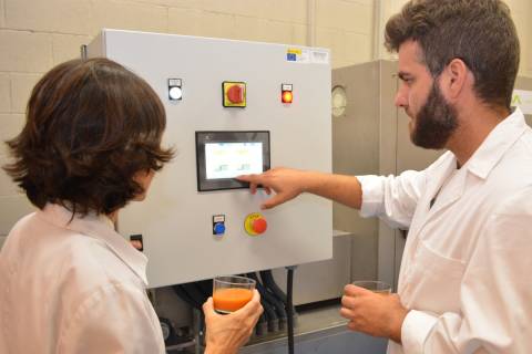 Dos investigadores de la Escuela de Agrónomos pasteurizando mediante un tratamiento térmico un batido de tomate.