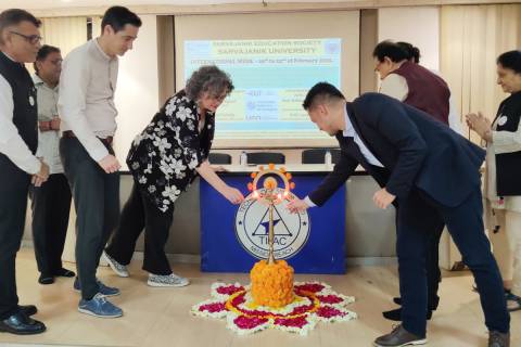 La rectora, Beatriz Miguel, encendiendo una vela en un elemento decorativo durante el encuentro con universidades indias.