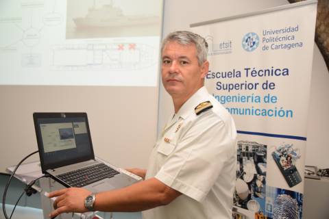 Heitor Martínez durante la defensa de su tesis, con una imagen de fondo de las vías de escape de un buque.
