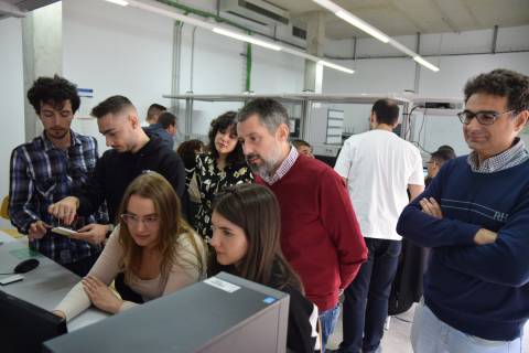 Estudiantes de EUt+ configurando un dispositivo, supervisados por Laura García, Rafael Asorey y Antonio Javier García.