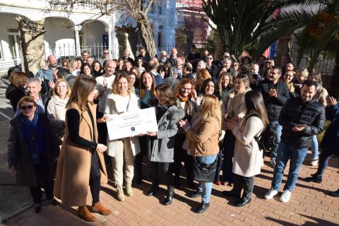 La vicerrectora de Investigación, Catalina Egea, y una de las madrinas de la candidatura entregan el cheque a una representante de AMUDEF.