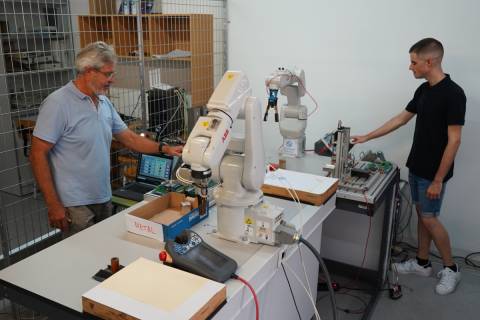 El director y el autor del TFM junto al robot manipulador.
