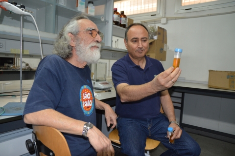 El docente chileno y el de la Universidad Politécnica de Cartagena sosteniendo un tubo que contiene cristales líquidos