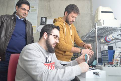 Antonio Javier García observando el trabajo de dos alumnos contratados por el grupo de investigación en Ingeniería Telemática.