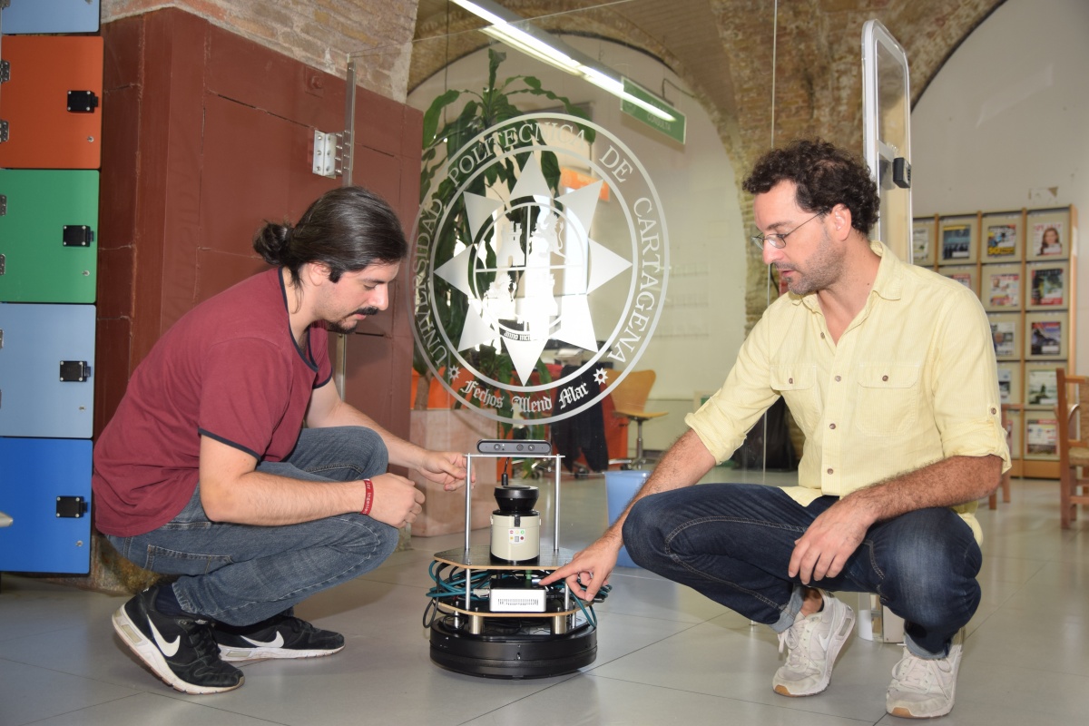 
En la imagen, de archivo, Óscar Mozos (a la derecha) con un robot diseñado para realizar funciones de bibliotecario.