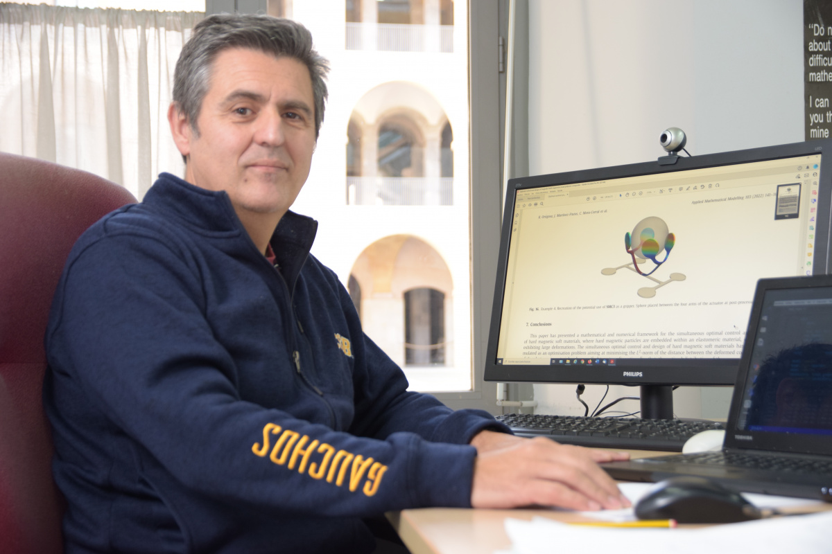 Francisco Periago en su despacho de la Escuela de Industriales, junto a una imagen del modulado de un material flexible.