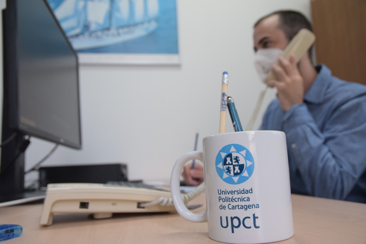 Imagen de un trabajador de la UPCT realizando varias tareas a la vez.